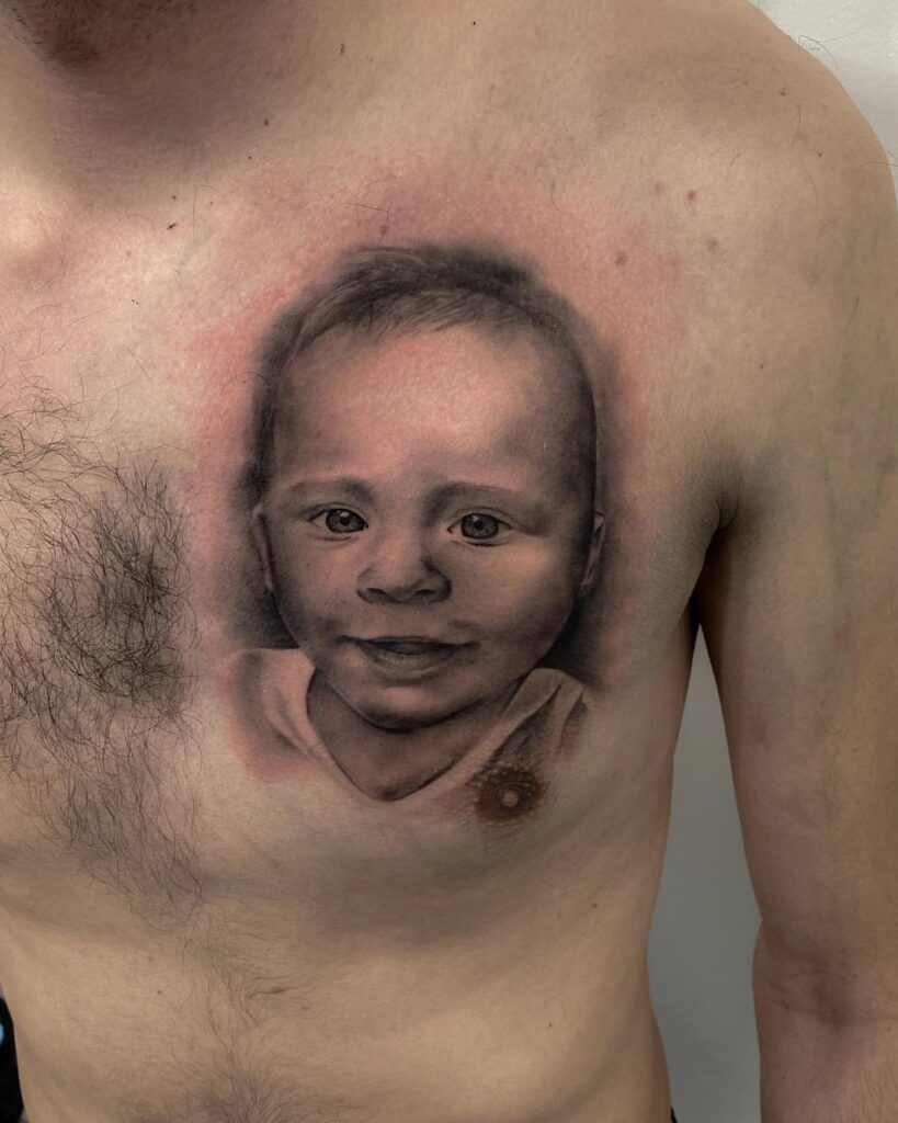 Realistic grayscale baby portrait on the chest, black and grey shading; tattoo project; not a cover-up.