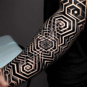 Arm in black and grey with a geometric labyrinth pattern; project idea for a cover-up.