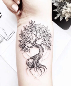 Tree with leaves and twisting roots in black ink; black and grey; on forearm; tattoo project; not specifically a cover-up.
